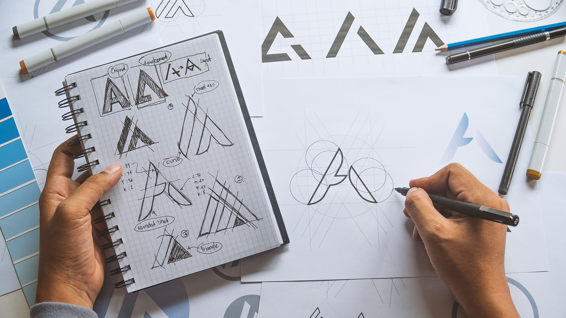 A logo designer designing a logo at his desk